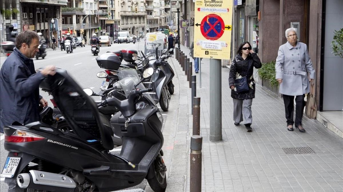 Espacio habilitado para motos y servicios sobre el asfalto de la calle de Balmes, en Barcelona.