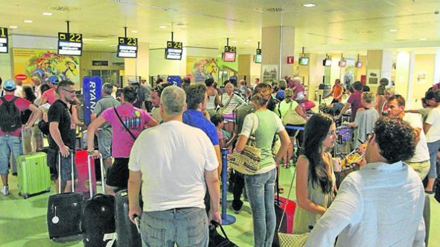 Pasajeros esperan con su equipaje ayer en el aeropuerto de Ibiza.