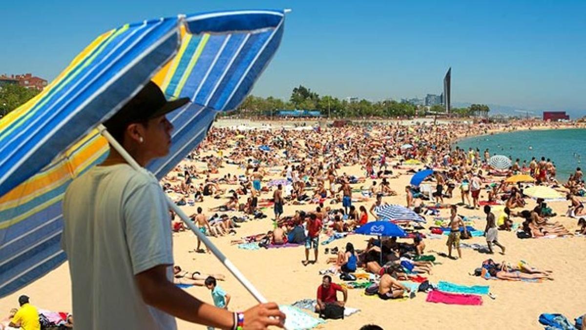 Imatge de la platja de Nova Icària, a Barcelona. Milers de banyistes van al mar durant els primers dies de sol.