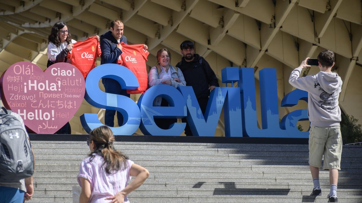 Aficionados del Real Club Deportivo Mallorca se fotografían con las letras de Sevilla este jueves antes de la Copa del Rey.