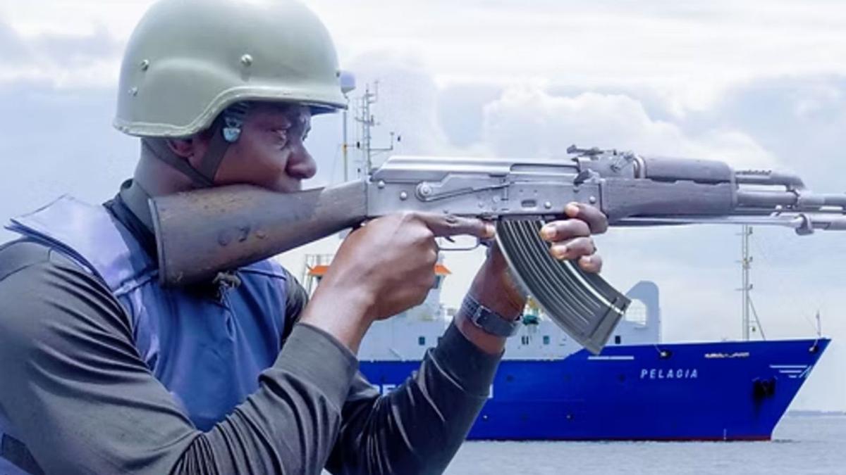 Un vigilante de seguridad privada de barcos empuña un fusil en alta mar.