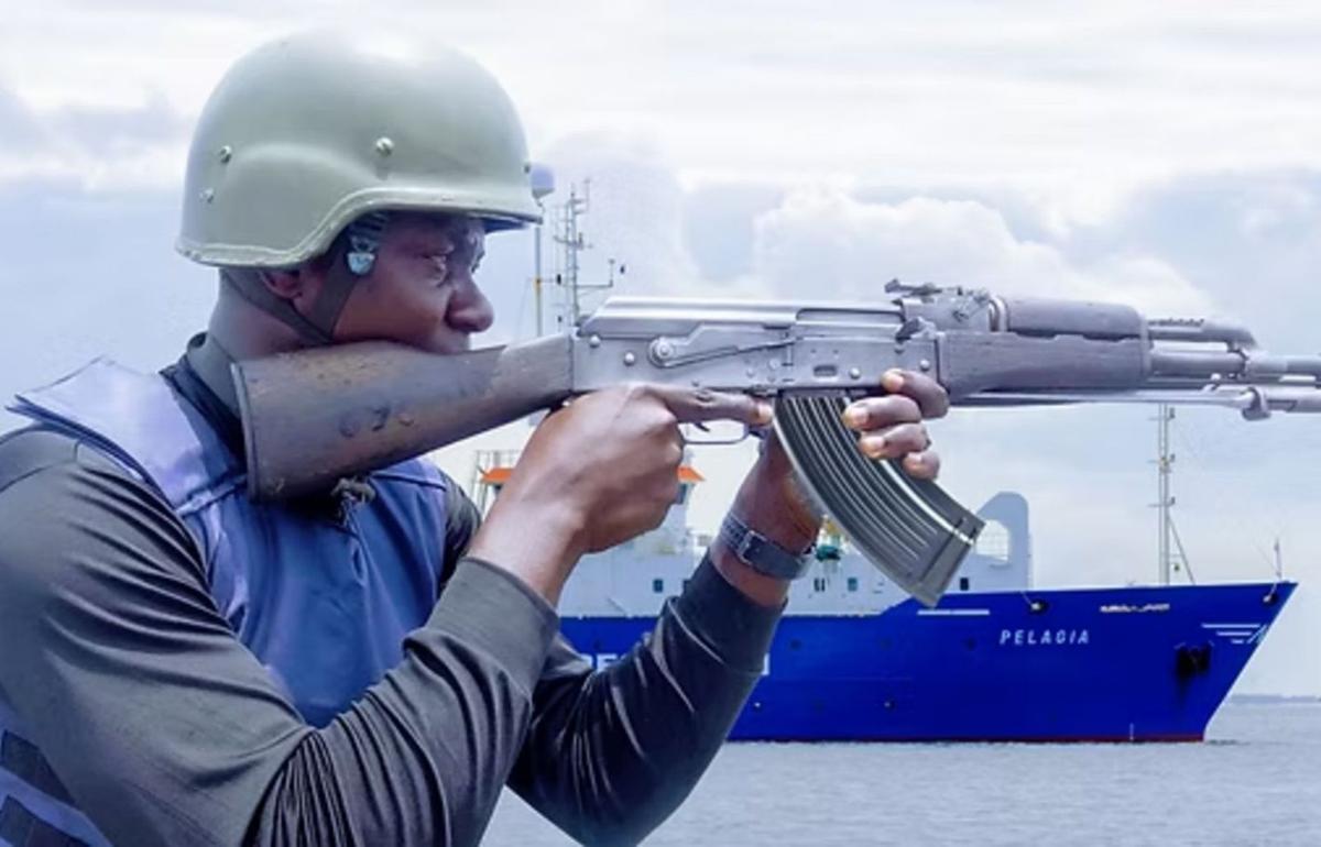 Un vigilante de seguridad privada de barcos empuña un fusil en alta mar.