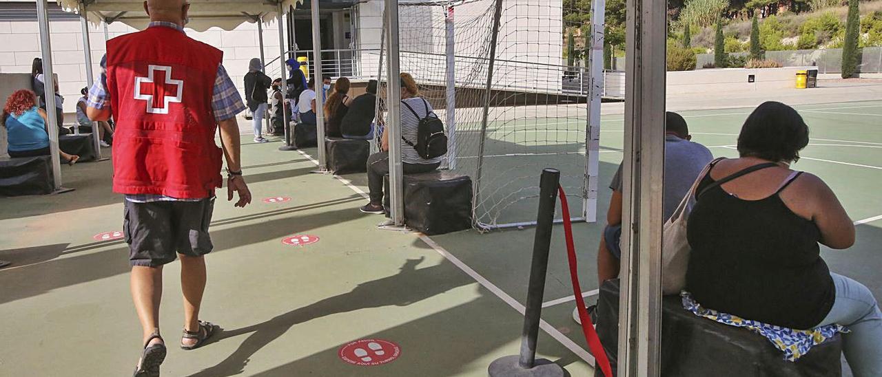 Personas esperando alimentos este viernes en Cruz Roja y recogida en Despensa Solidaria. | PILAR CORTÉS