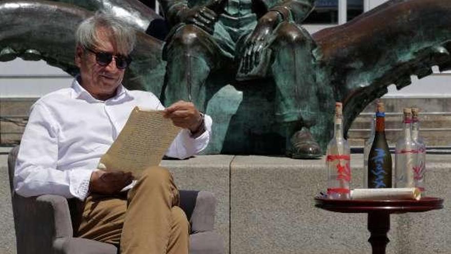 Fernando Franco, junto a la estatua de Verne y unas botellas. // T.F.