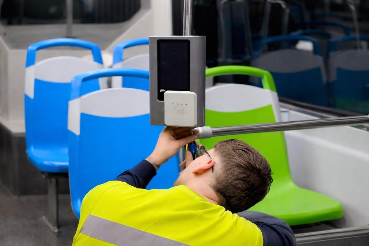 Un técnico instala el sistema para pagar con tarjeta en un bus de la EMT.