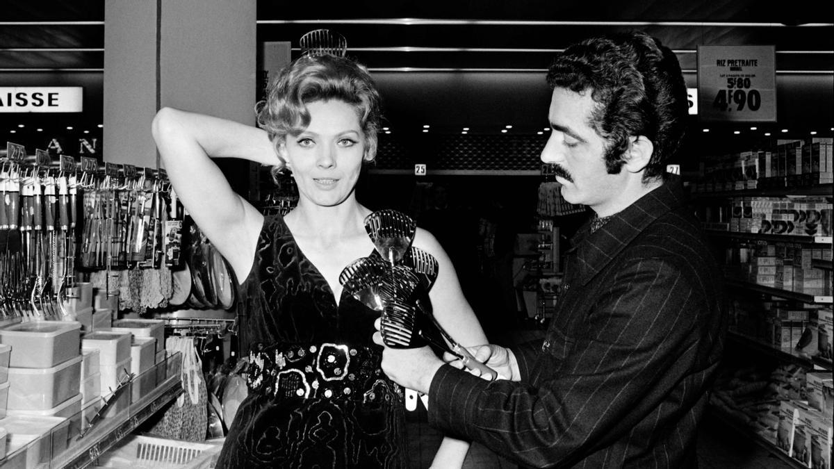 El diseñador Paco Rabanne probando una de sus piezas con la actriz francesa Corinne Marchand en 1969