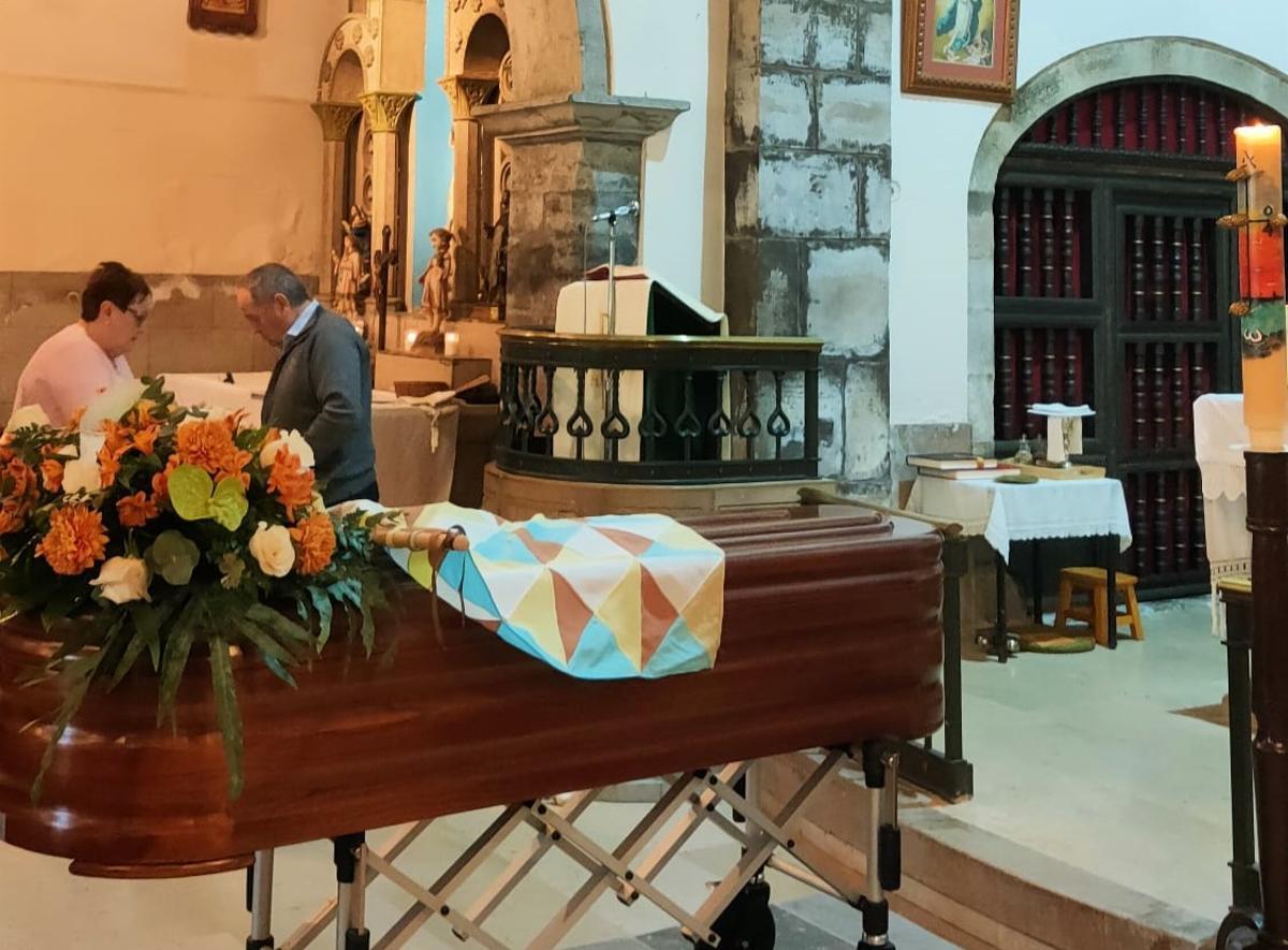 El féretro, cubierton con la bandera del "toréu del Santu", en la iglesia parroquial de Piñeres.