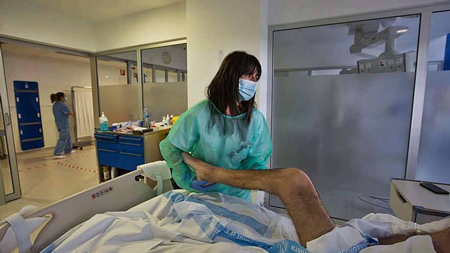 Raquel Zafra flexiona la rodilla de uno de los pacientes covid ingresados en la UCI del Hospital Can Misses. | VICENT MARÍ