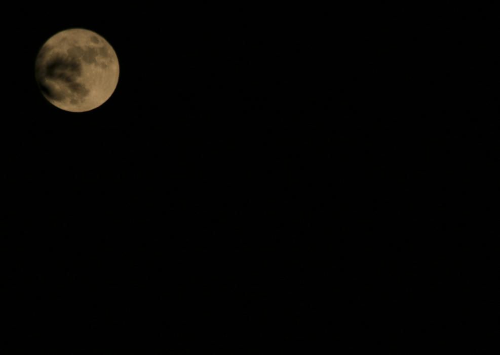 La superluna en Málaga se vio enturbiada por los cielos nubosos de la tarde del lunes.