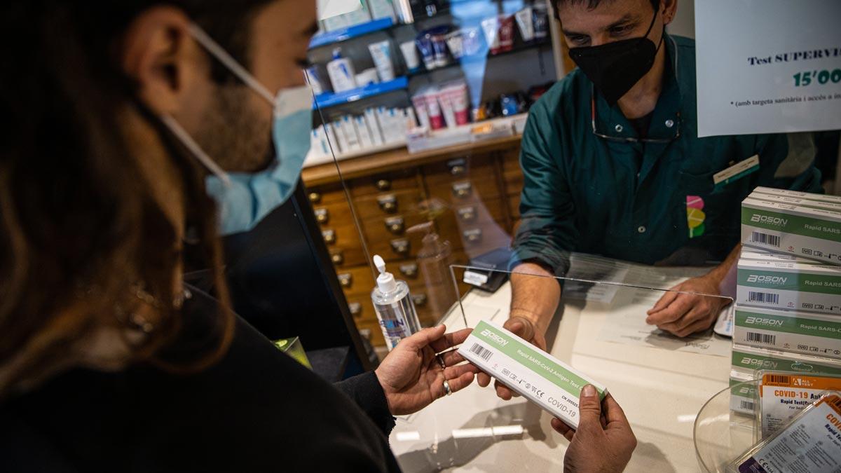 Un chico compra un test de antígenos en una farmacia de Barcelona