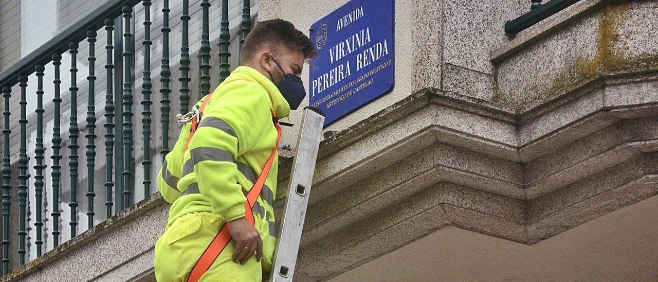 Un trabajador instala la placa con el nuevo nombre de la calle Virxinia Pereira Renda.   | // FDV