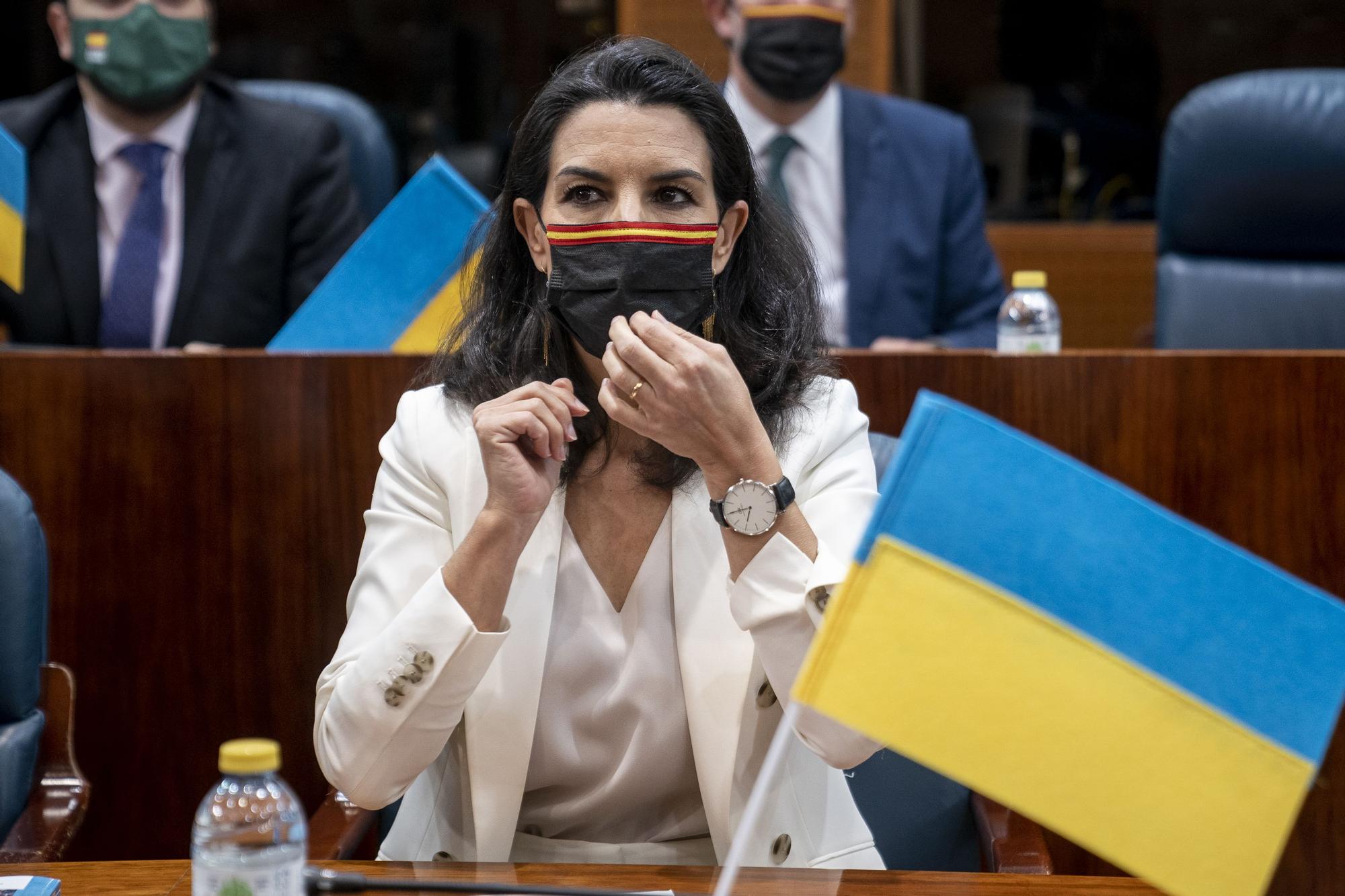 La portavoz del Grupo Parlamentario de Vox, Rocío Monasterio, con una bandera de Ucrania en una sesión del pleno de la Asamblea de Madrid.