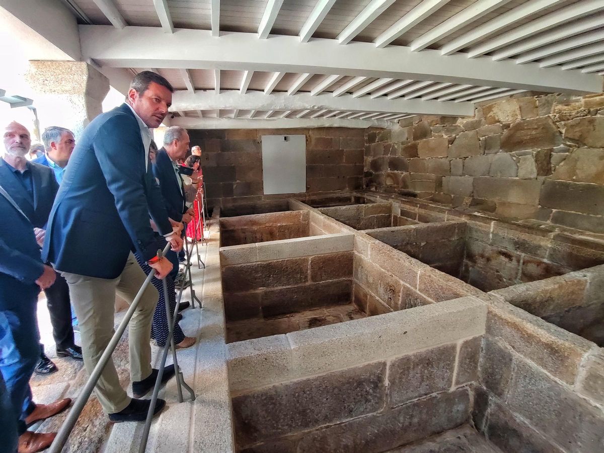 El conselleiro López Campos observa los pilos de la antigua Salazón Piñeiro.