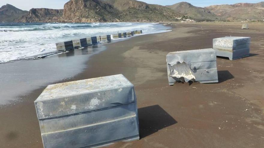 Unas 80 cajas metálicas invaden la orilla de la bahía de Portmán.