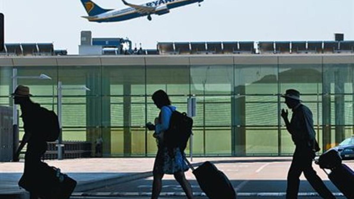 Despegue de un avión y trajín de pasajeros en el aeropuerto de El Prat, el pasado verano.