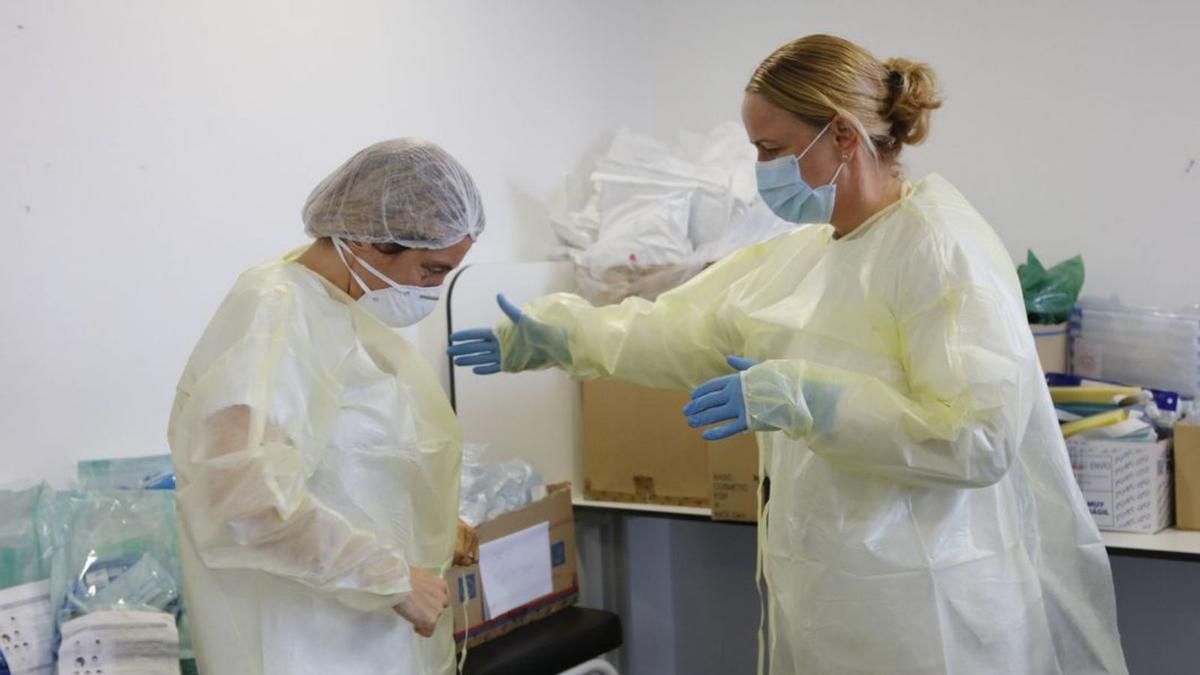 Krankenschwester Maret Seibt und Diana Garau aus dem Gesundheitszentrum Porto Cristo auf Mallorca ziehen Schutzkleidung an.