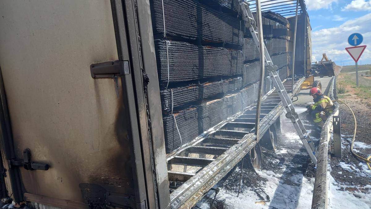 Bomberos de la Diputación del Parque de Almazán intervienen en el incendio de en la caja de un camión trailer con tableros en la A-15
