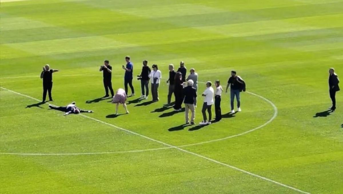 Joan Laporta tumbado sobre el césped del Spotify Camp Nou, con parte de su séquito.