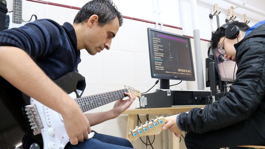 El professor de música ajuda un dels alumnes durant la classe, a l&#039;institut Sis de Manresa