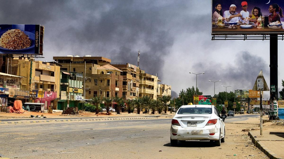 Humo de los bombardeos en una calle de Jartum casi desierta, este sábado.