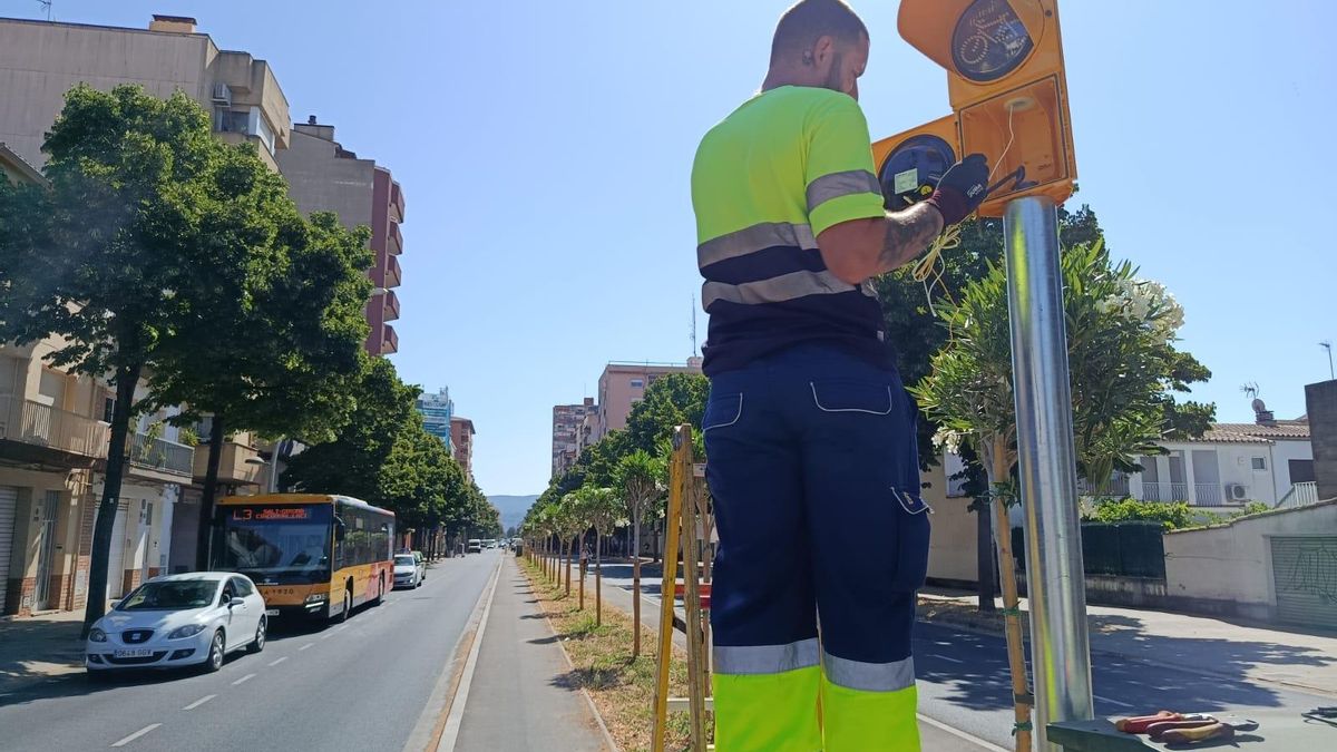 Un operari instal·lant un semàfor per a bicicletes al passeig dels Països Catalans.