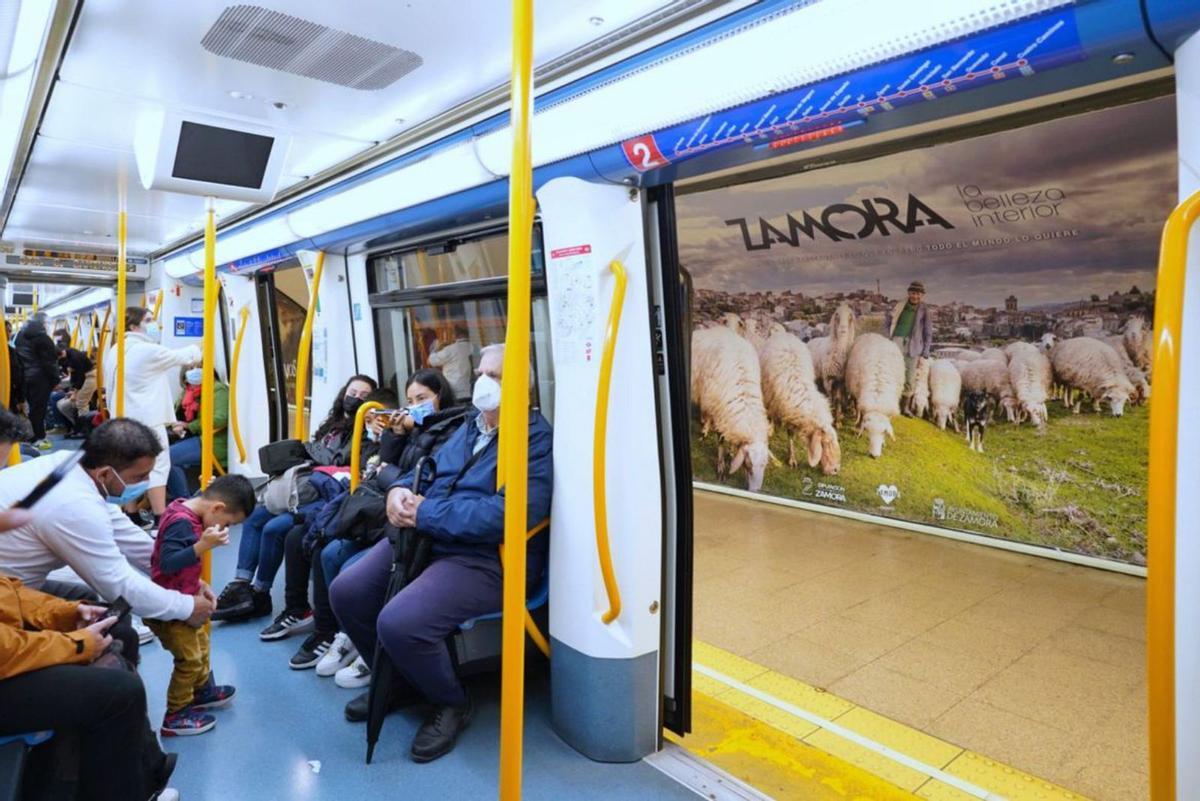 Usuarios del metro y al fondo una de las imágenes de la provincia. | José Antonio Pascual
