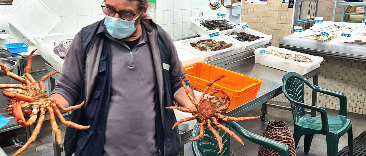 El subastador de la lonja muestra una pareja de centollos en la pescadería del pósito.