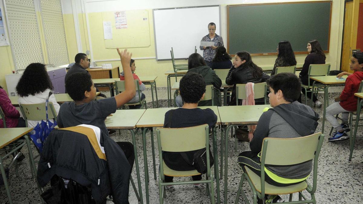Un grupo de alumnos atiende a un profesor en un instituto de Secundaria.