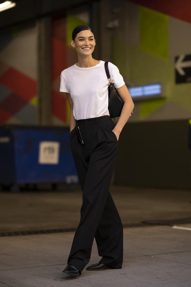 Modelo con camiseta blanca y pantalones negros