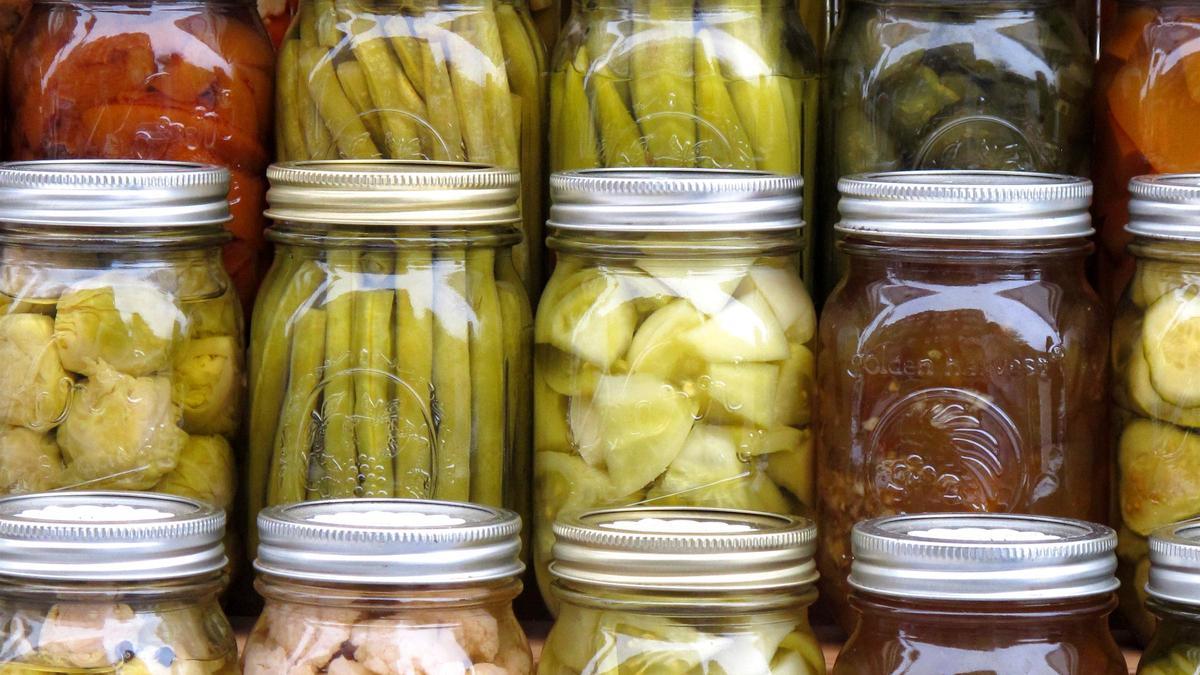 Verduras en escabeche como zanahorias, judías verdes, tomates y coliflor se exhiben en un mercado de agricultores