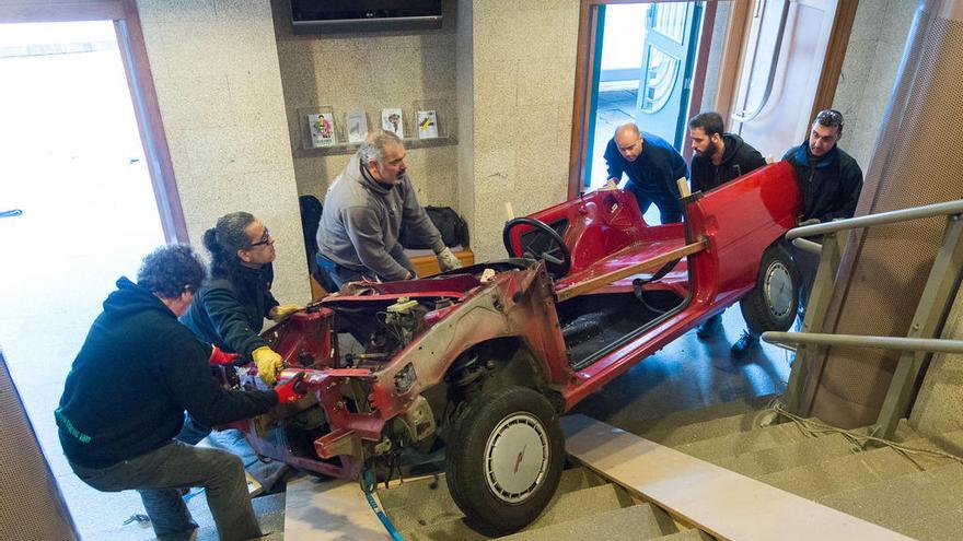 Varios hombres metiendo el coche en el Salón Teatro. // FdV