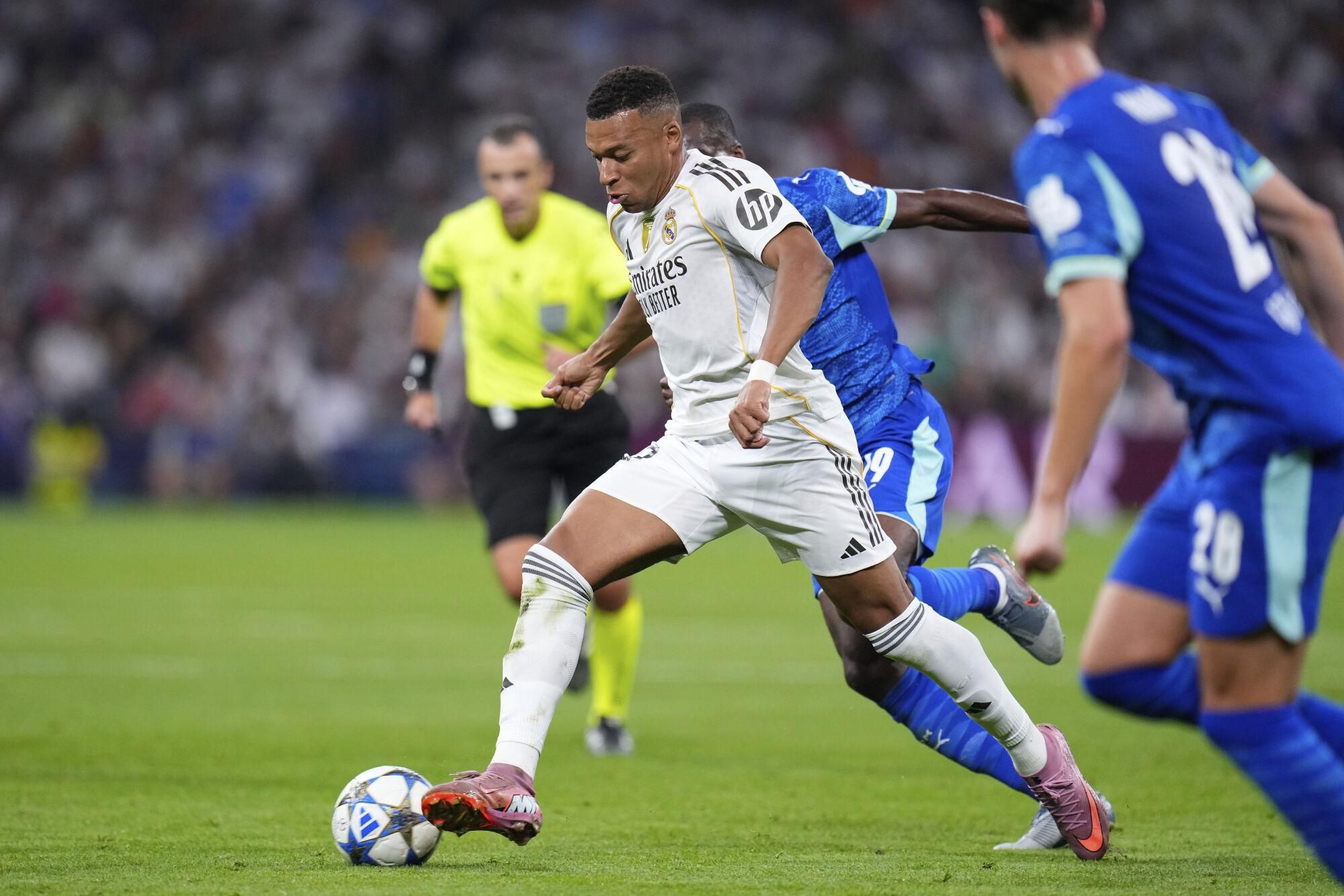 Real Madrid's Kylian Mbappe runs with the ball during a Champions League opening phase soccer match between Real Madrid and Marseille at Santiago Bernabeu stadium, in Madrid, Tuesday, Sept. 16, 2025. (AP Photo/Manu Fernandez)