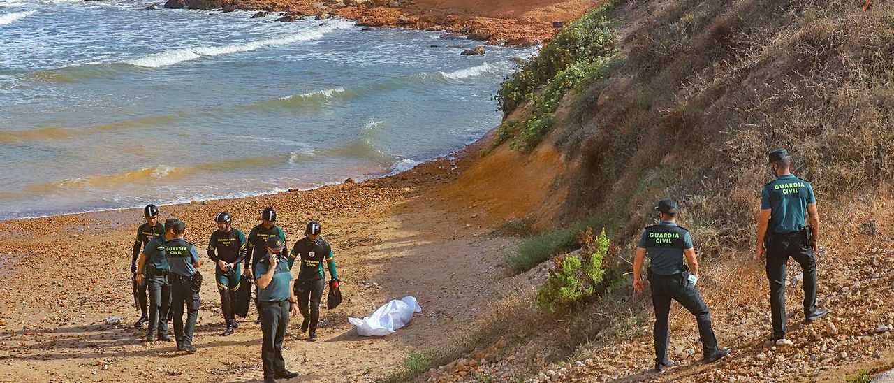 Efectivos de la Guardia Civil junto al cuerpo del bañista ahogado en Torrevieja. | TONY SEVILLA