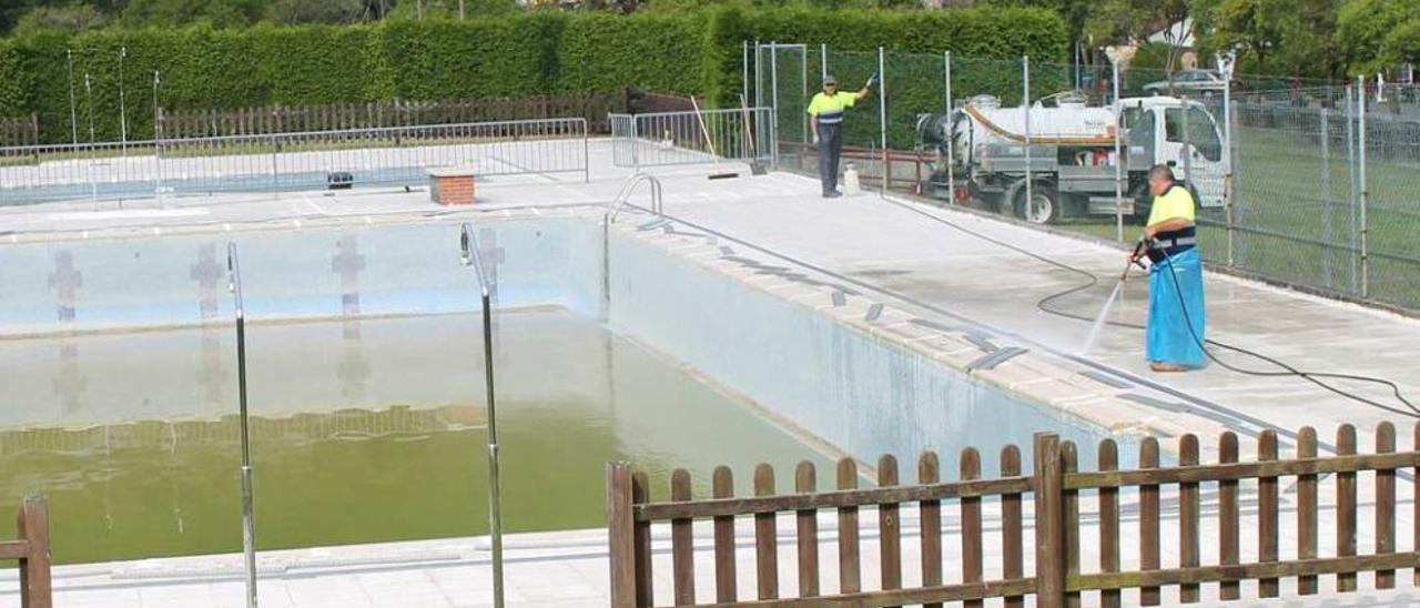 Operarios acondicionando las piscinas de La Cueva de Piloña, ayer.