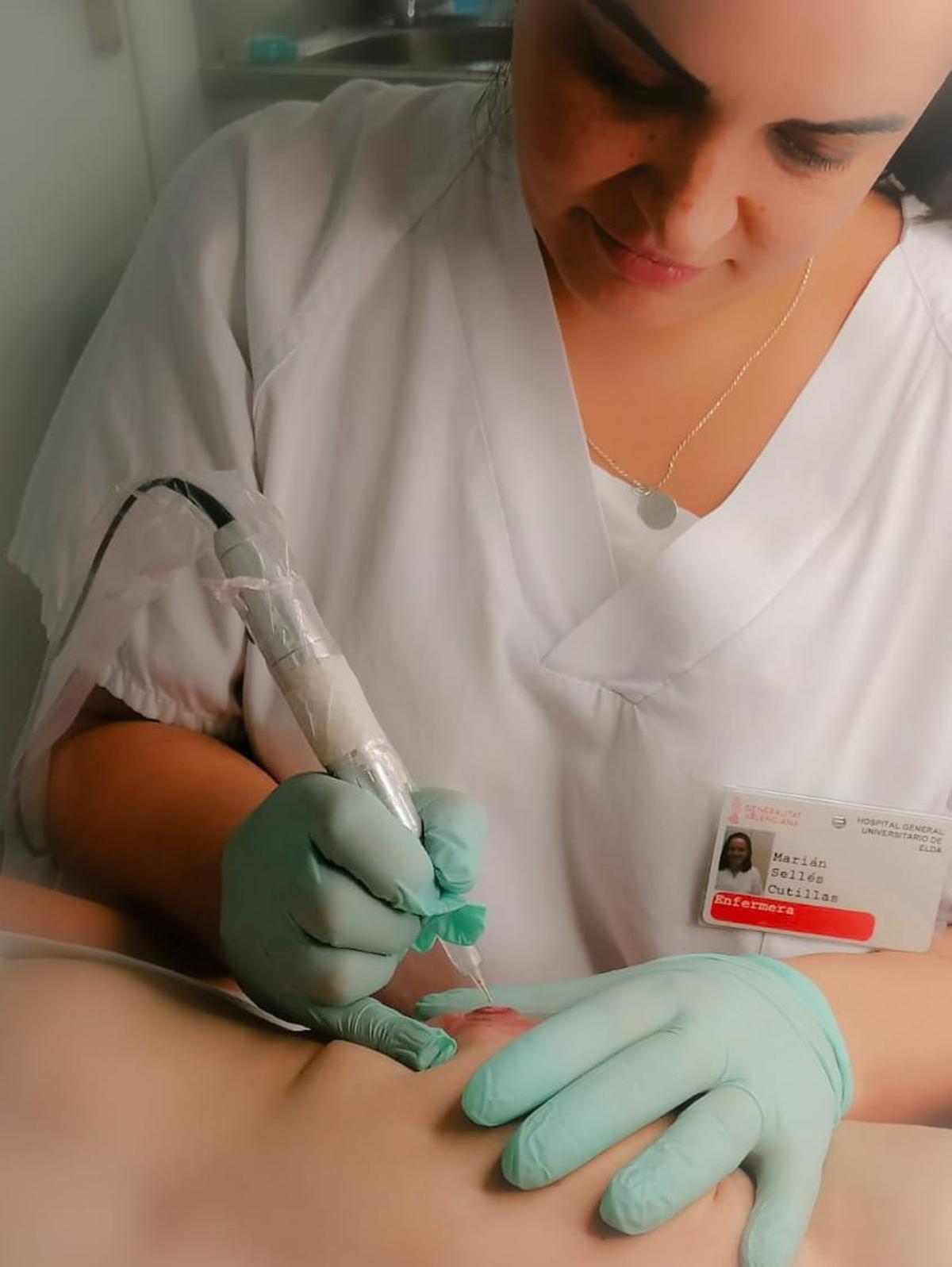 La enfermera Marián Sellés, durante una sesión a una paciente en el Hospital de Elda.