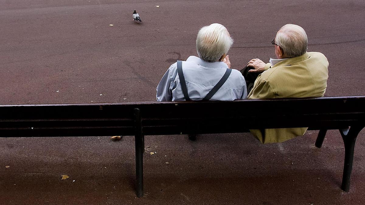 Dos jubilados sentados en un banco.