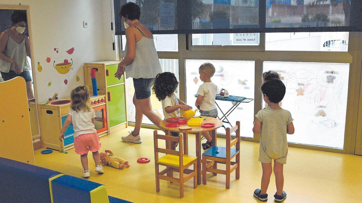 Una profesora atiende a varios niños en la escuela infantil municipal El Lugarico de El Palmar, en Murcia.