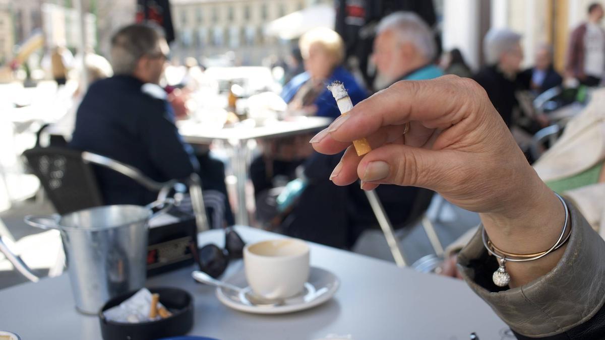 Una dona fumant en una terrassa.