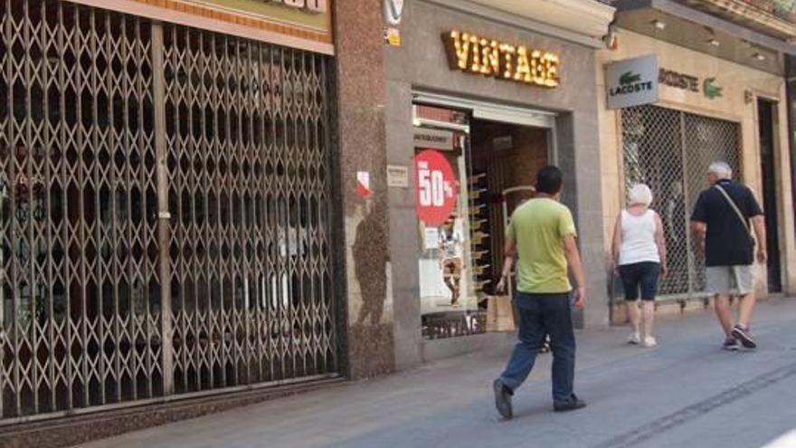 El centre de Figueres, el dia de Sant Pere, amb comerços oberts i tancats.