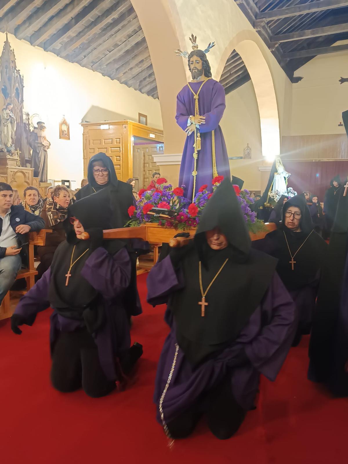 Penitentes avanzan con una imagen de Cristo a hombros por el pasillo central de la iglesia de Manganeses de la Lampreana.