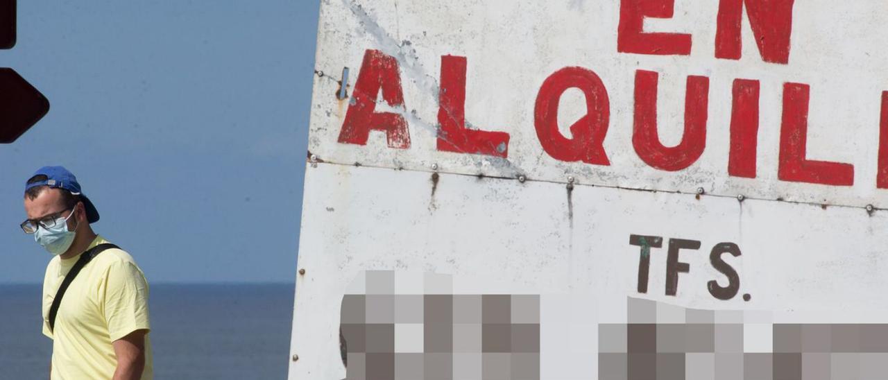Un hombre pasa al lado de un gran cartel que anuncia viviendas en alquiler en el sur de Tenerife. | | EUROPA PRESS