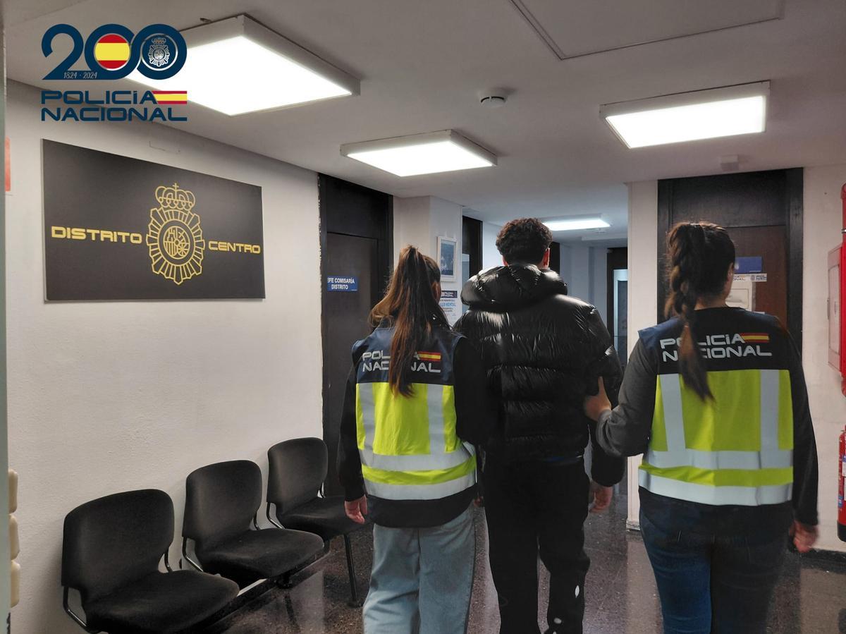 Agentes de la Policía Nacional llevan detenido a uno de los tres presuntos asaltantes.