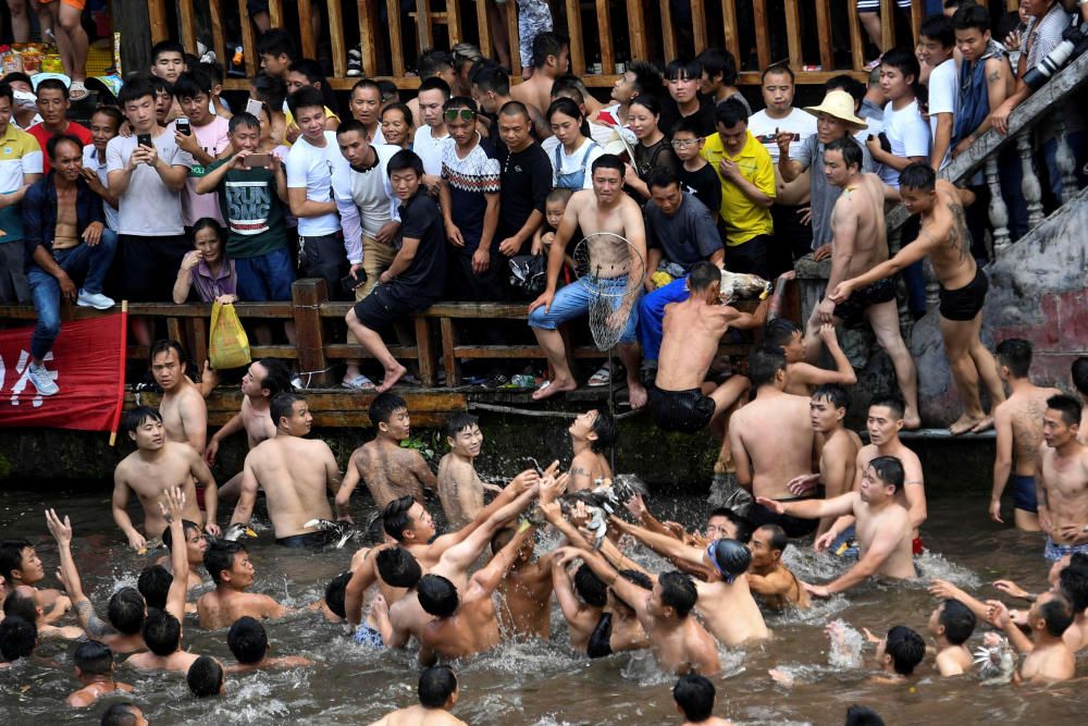 Men catch ducks in Tuojiang river during the ...