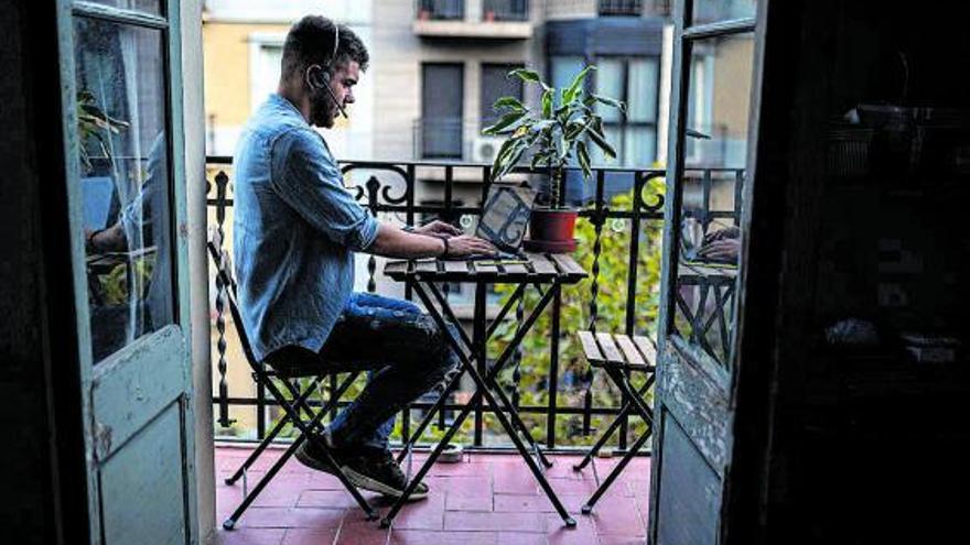 Un empleado trabaja desde  el balcón de  su casa.  |   // JORDI OTIX