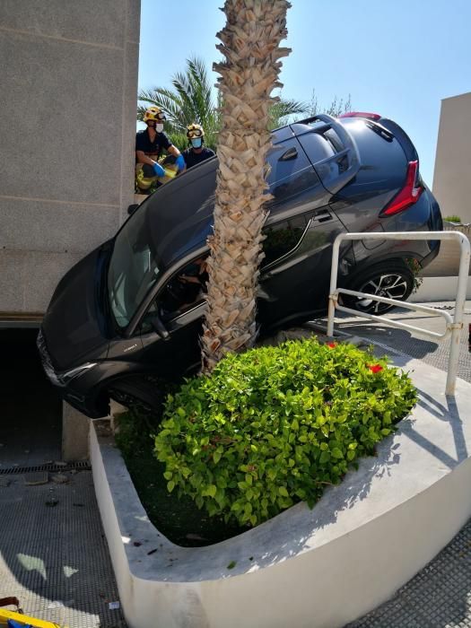 Dos ocupantes de un vehículo han sido rescatados por los bomberos de Alicante tras quedar su coche suspendido entre una palmera y una pared en el acceso de una urbanización de Alicante.