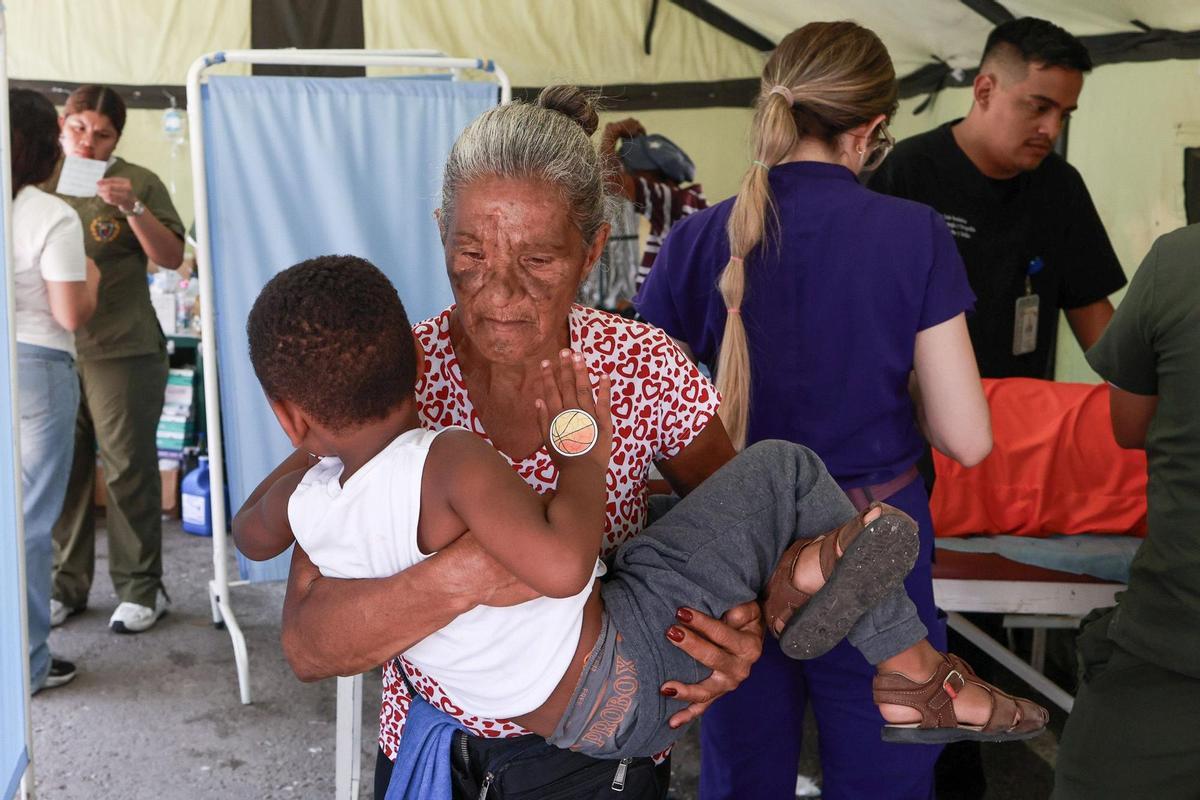 Un mujer lleva en brazos a un niño en un hospital