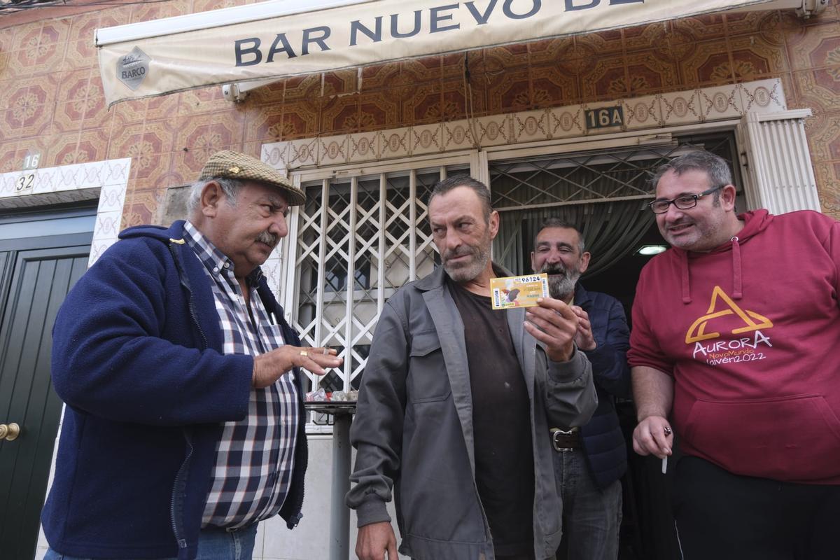 Isidro Vázquez, con el cupón premiado en la mano, bromea con un amigo a las puertas del Bar Betis.