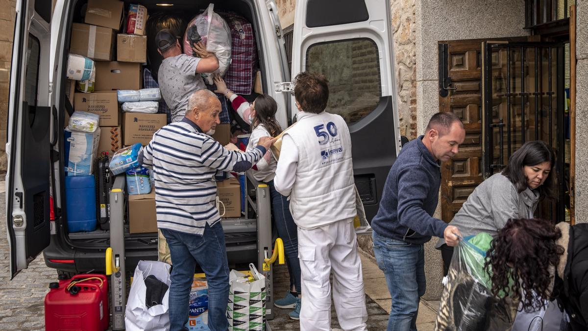 Alfonso (con gorra), y otros vecinos de la localidad de Torrelaguna en España cargan una furgoneta, del total de seis vehículos, con ayuda humanitaria para llevar a la ciudad polaca de Medyka en la frontera con Ucrania