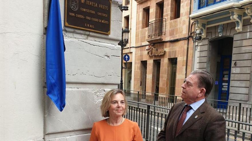 Alfredo Canteli, junto a Gemma Losa, mirando la placa dedicada a María Teresa Prieto en la Escuela municipal de Música. | LNE