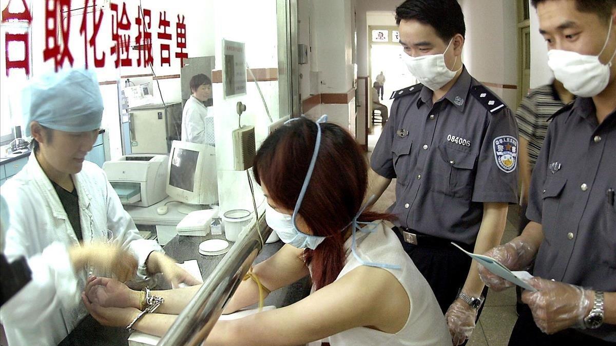 zentauroepp1320134 china out   a woman suspect in handcuffs gets tested for sar200107162849